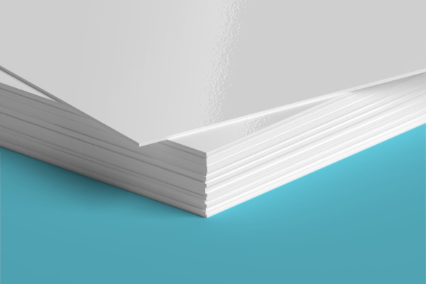 A close up of a stack of white paper on a blue surface.
