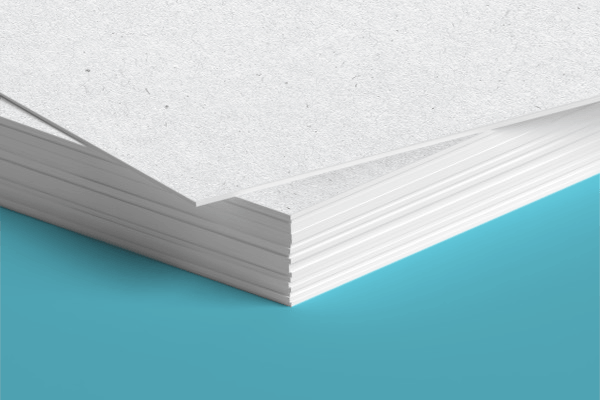 A close up of a stack of white paper on a blue surface.