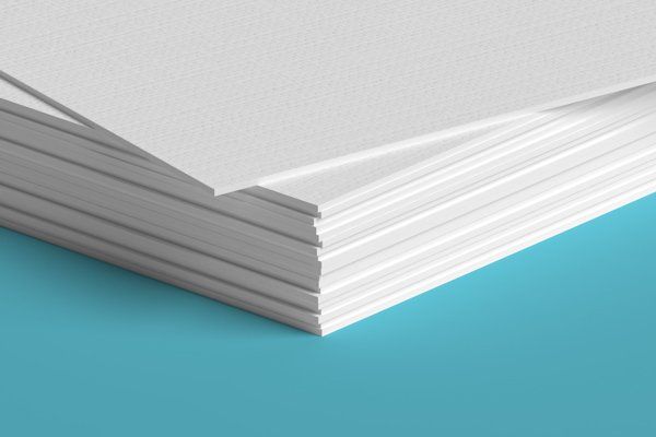 A close up of a stack of white paper on a blue surface.
