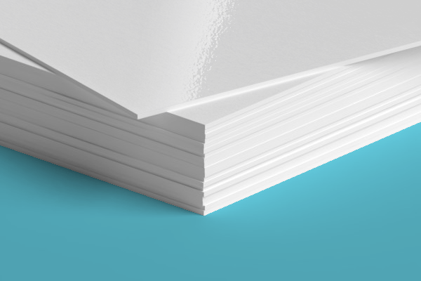 A close up of a stack of white paper on a blue surface.
