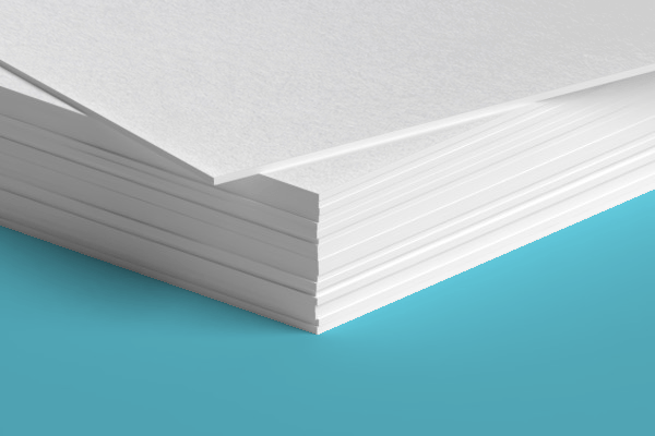 A close up of a stack of white paper on a blue surface.