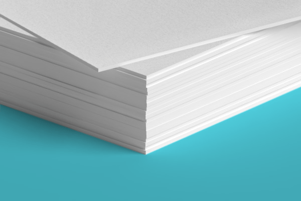 A close up of a stack of white paper on a blue surface.
