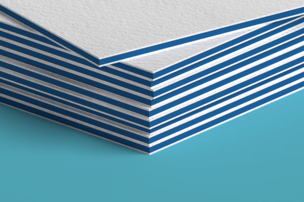 A close up of a stack of business cards on a blue surface.