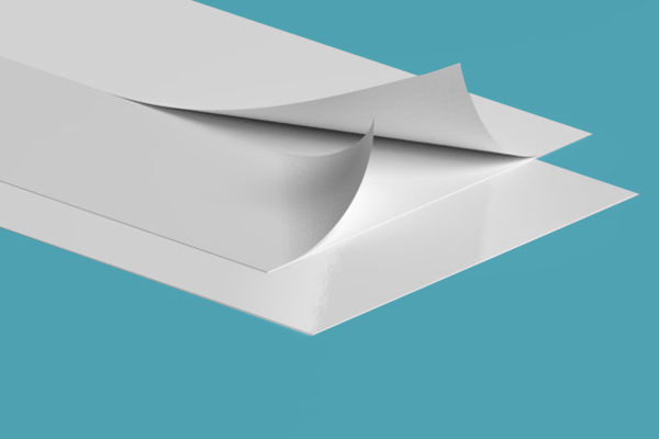 Two pieces of white paper are stacked on top of each other on a blue surface.