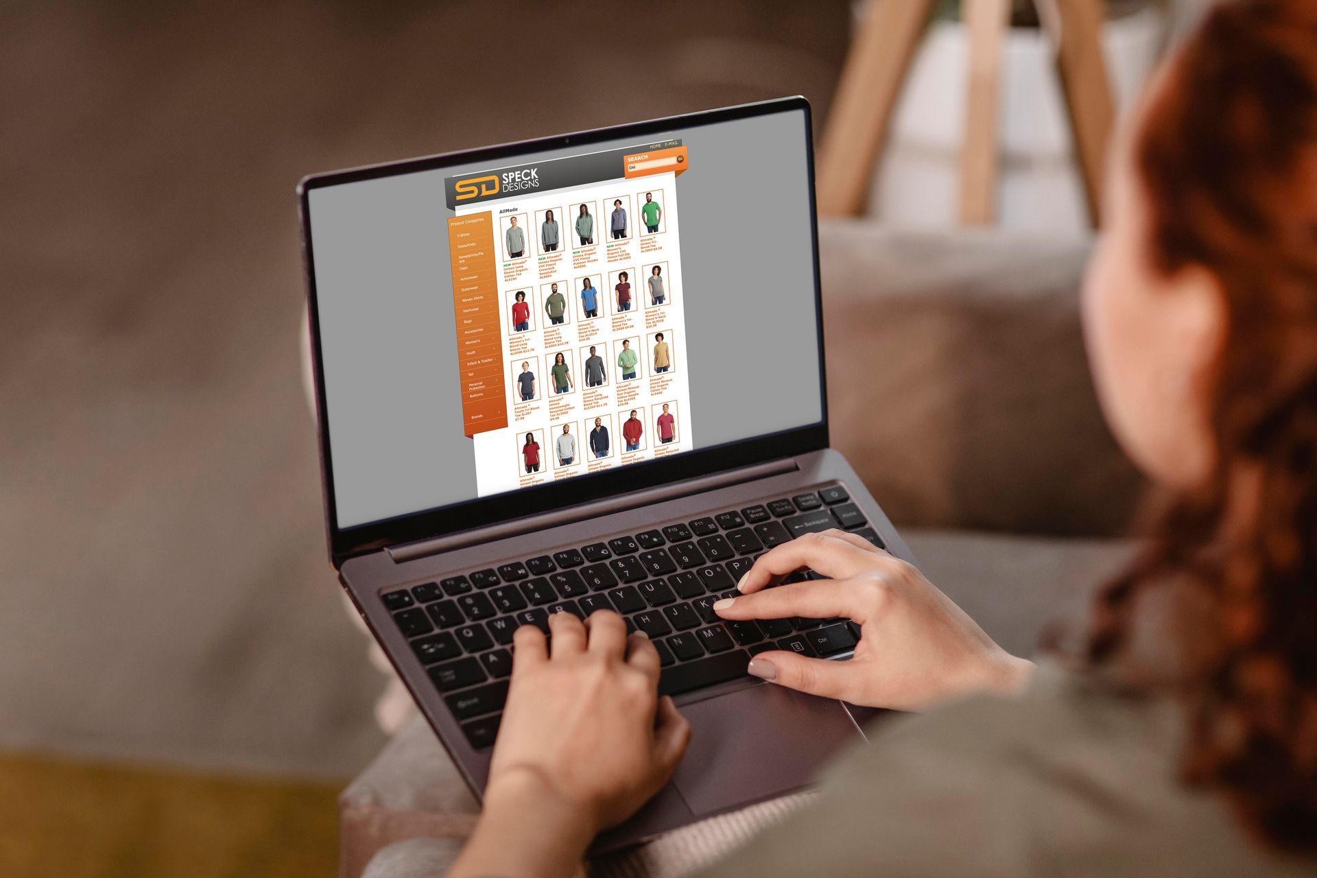 A woman is sitting in a chair holding a laptop with a website on the screen.