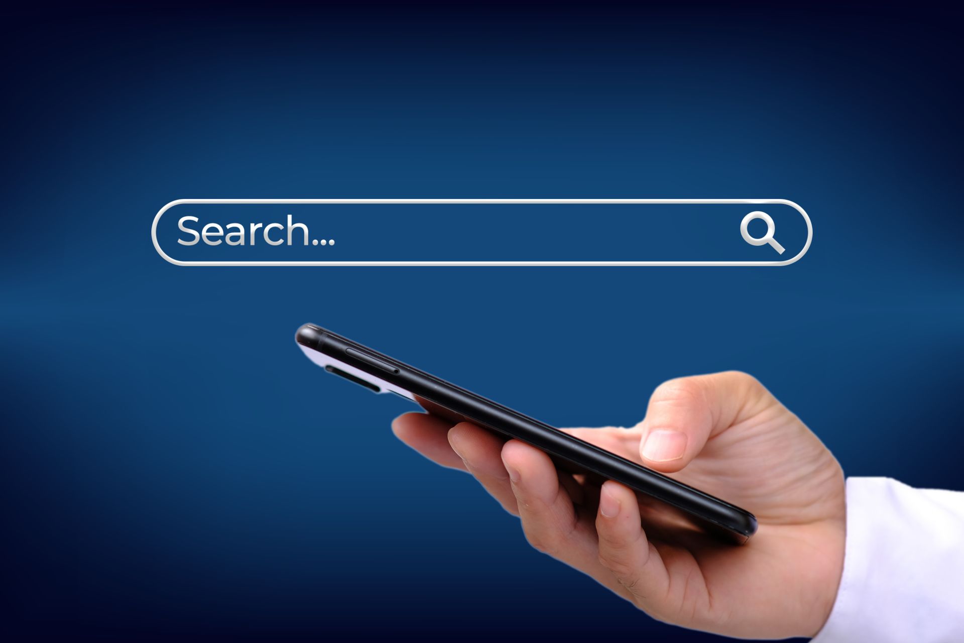 A hand is holding a cell phone with a search bar on the screen.