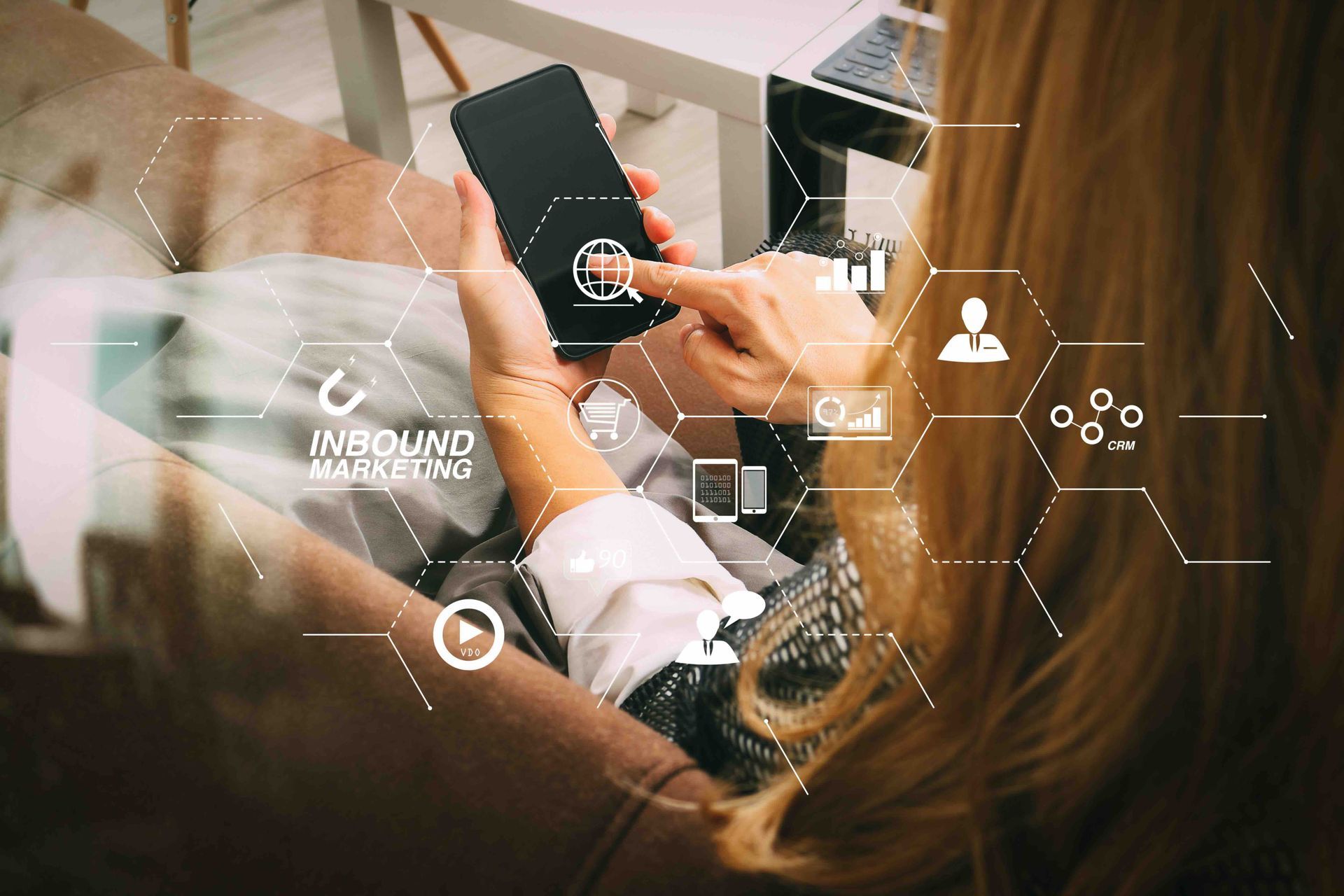 Woman using a smartphone, overlaid with inbound marketing-related icons, indoors.