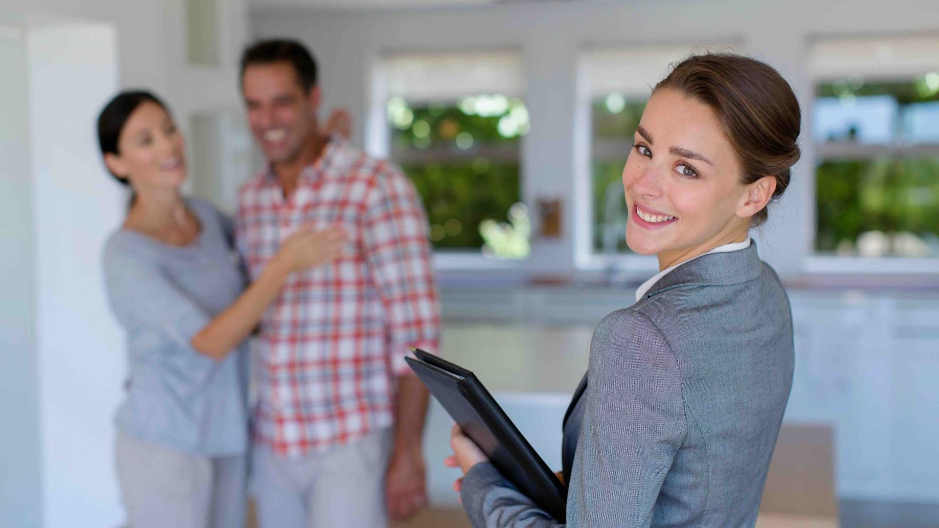 A woman is holding a clipboard in front of a man and woman.