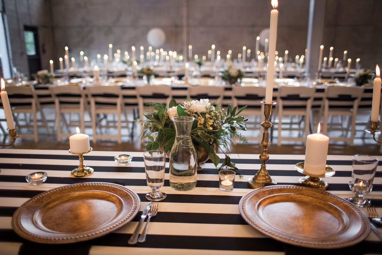 A long table with plates and candles on it