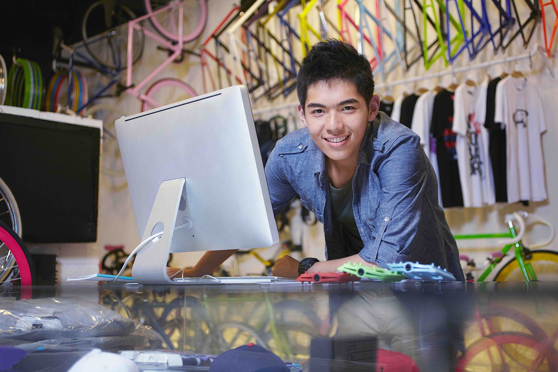 A man is standing in front of a computer in a store.