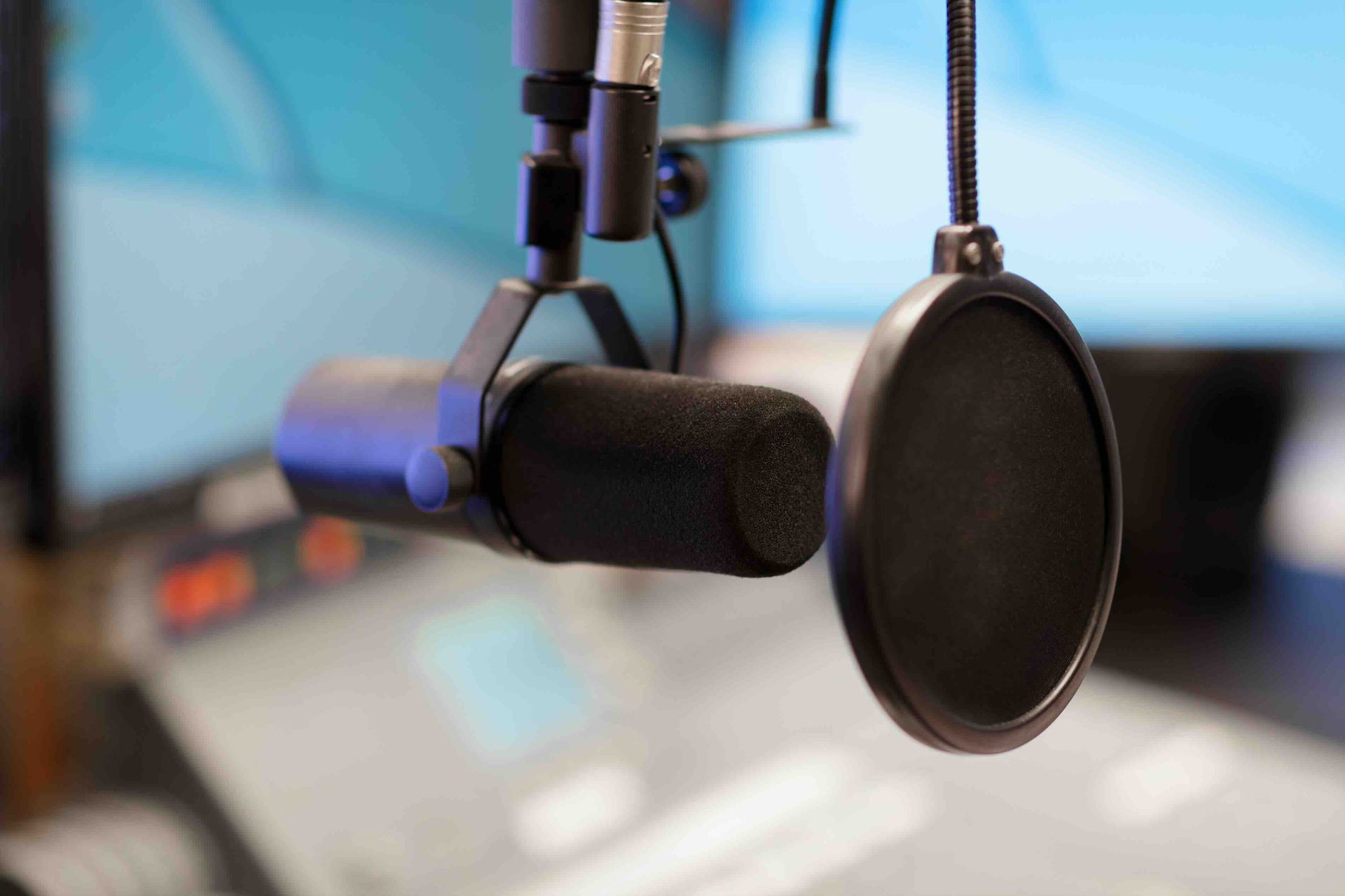 A close-up of a microphone and a pop filter in a radio studio.