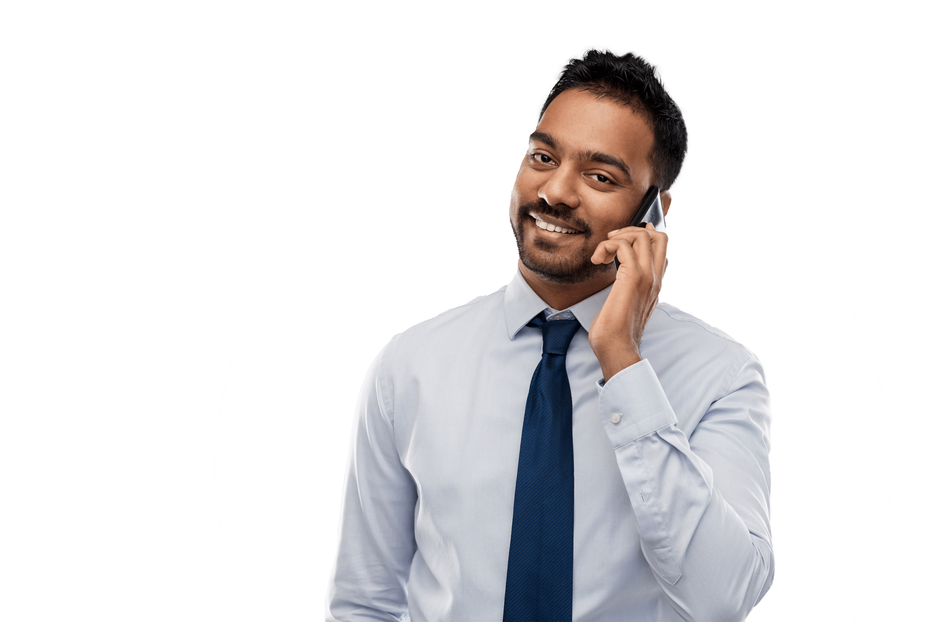 A man in a white shirt and blue tie is talking on a cell phone.