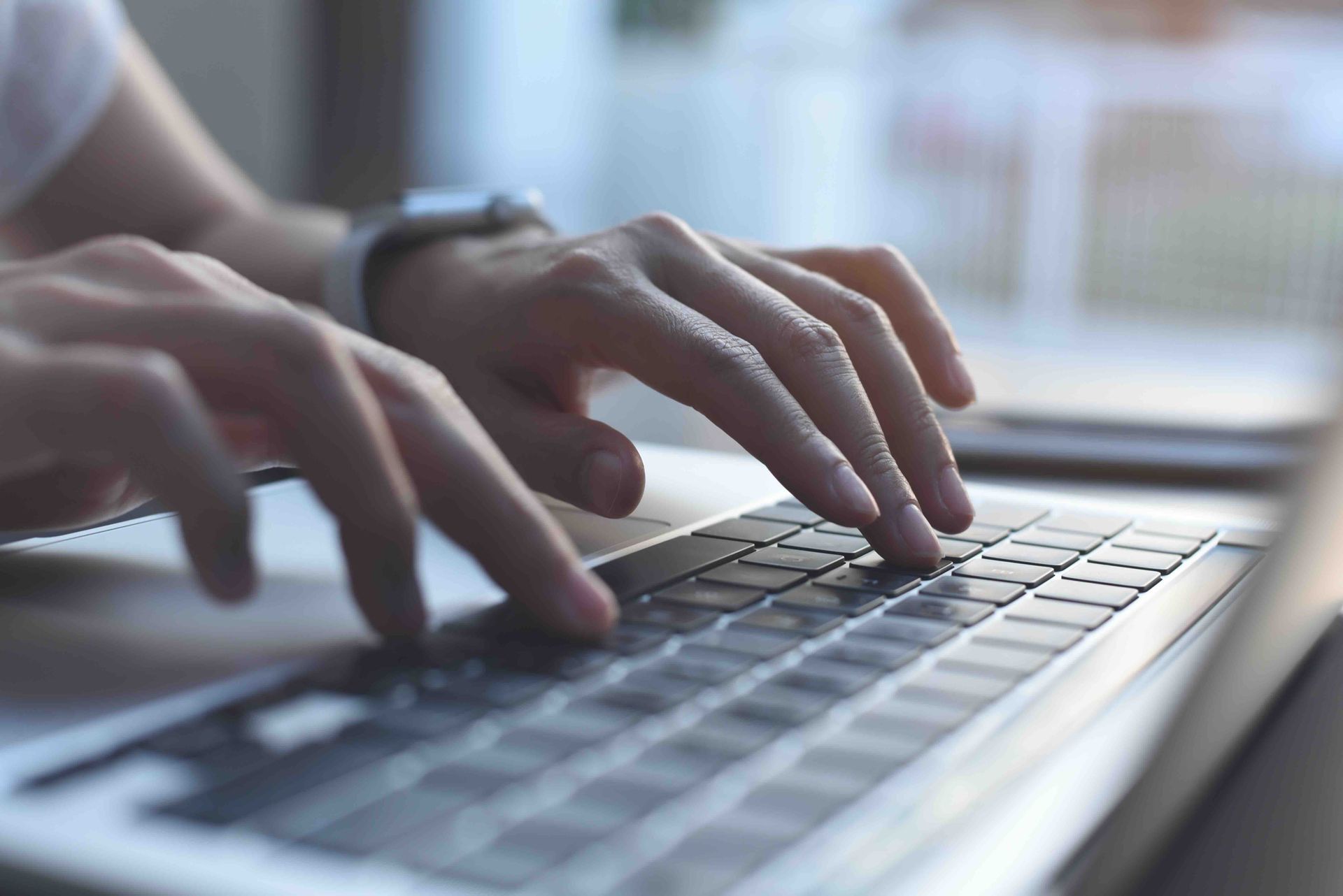 A person is typing on a laptop computer.