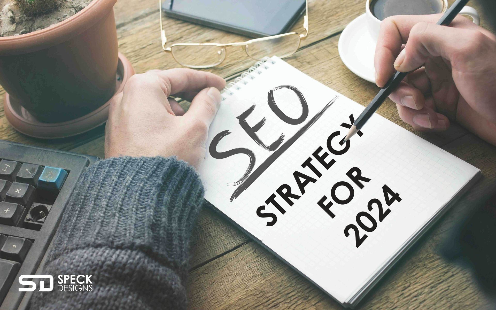 A person is writing in a notebook about their seo strategy for 2024.