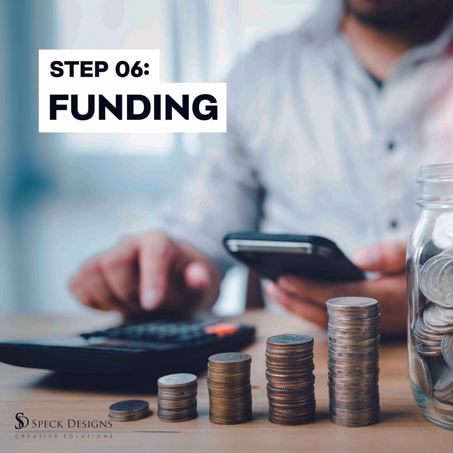 A man is sitting at a table with stacks of coins and a jar of coins.