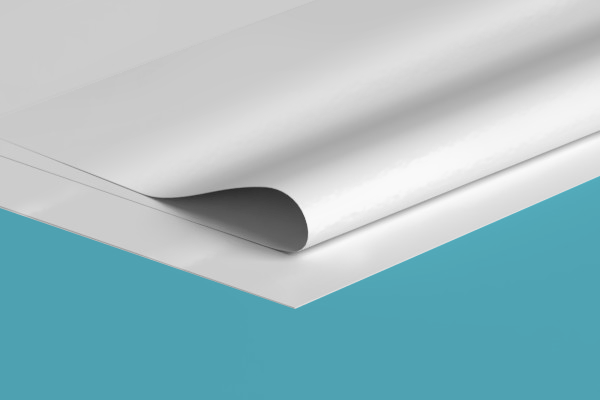 A close up of a piece of white paper on a blue surface.