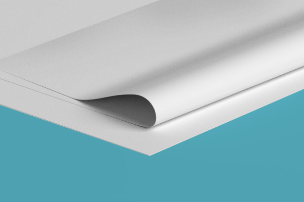 A close up of a piece of white paper on a blue surface.