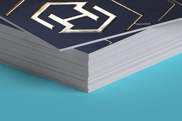 A close up of a stack of business cards on a blue surface.