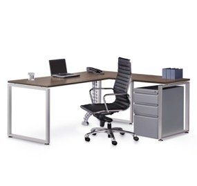 L-shaped office desk with a laptop, chair, phone, and storage. Brown tabletop, silver frame and file cabinet.