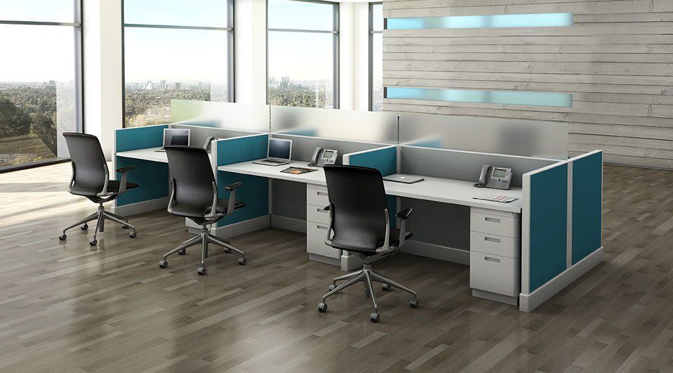 Office cubicles with teal accents, black chairs, and light wood floors.