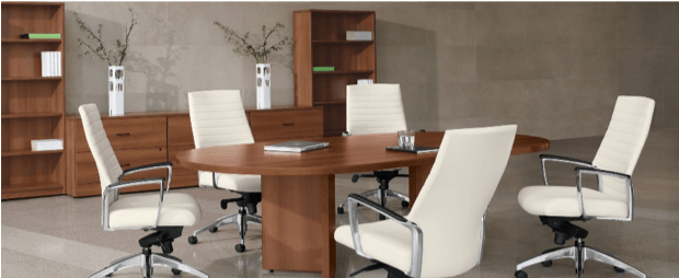 Conference room with oval wooden table, white leather chairs, and wooden bookshelves.
