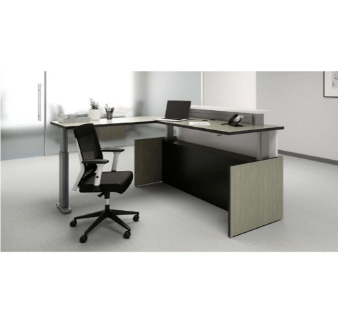 L-shaped office desk with a height-adjustable section, a black office chair, and a laptop.