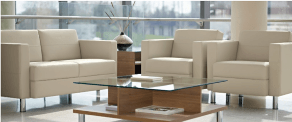 A living room with beige sofas, chairs, a coffee table, and a vase in front of a large window.