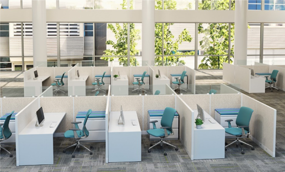 Modern office cubicles with white desks, teal chairs, and light blue cushions, bathed in natural light.