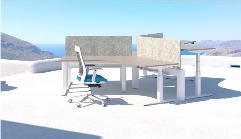 Office desks with a blue chair on a white terrace overlooking the sea.