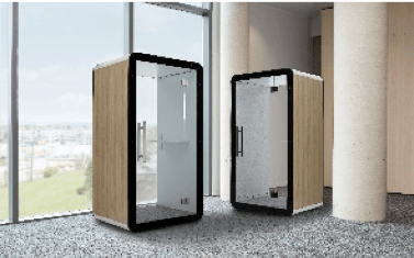 Two soundproof phone booths with glass doors, wood trim, and a cityscape background.