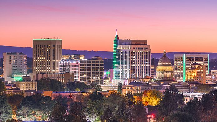 Boise, Idaho skyline at dusk; buildings with lights, pink and purple sky.