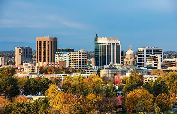 Boise, Idaho skyline with blue sky, trees in fall colors, and the state capitol building.