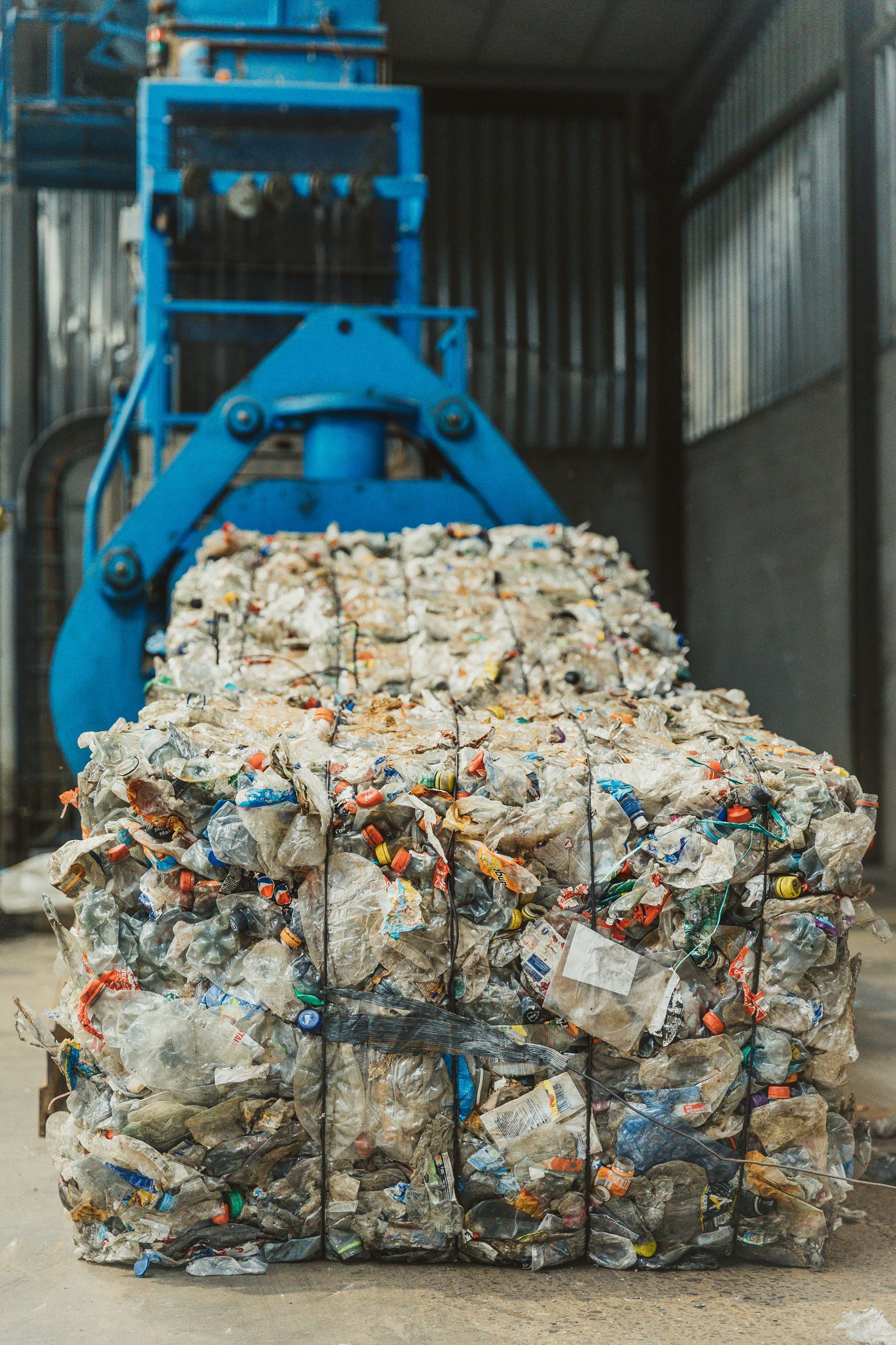 Een grote stapel plastic flessen wordt door een kraan opgetild.