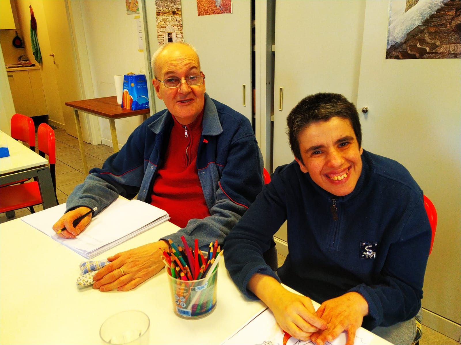 Un uomo e un ragazzo sono seduti a un tavolo e sorridono