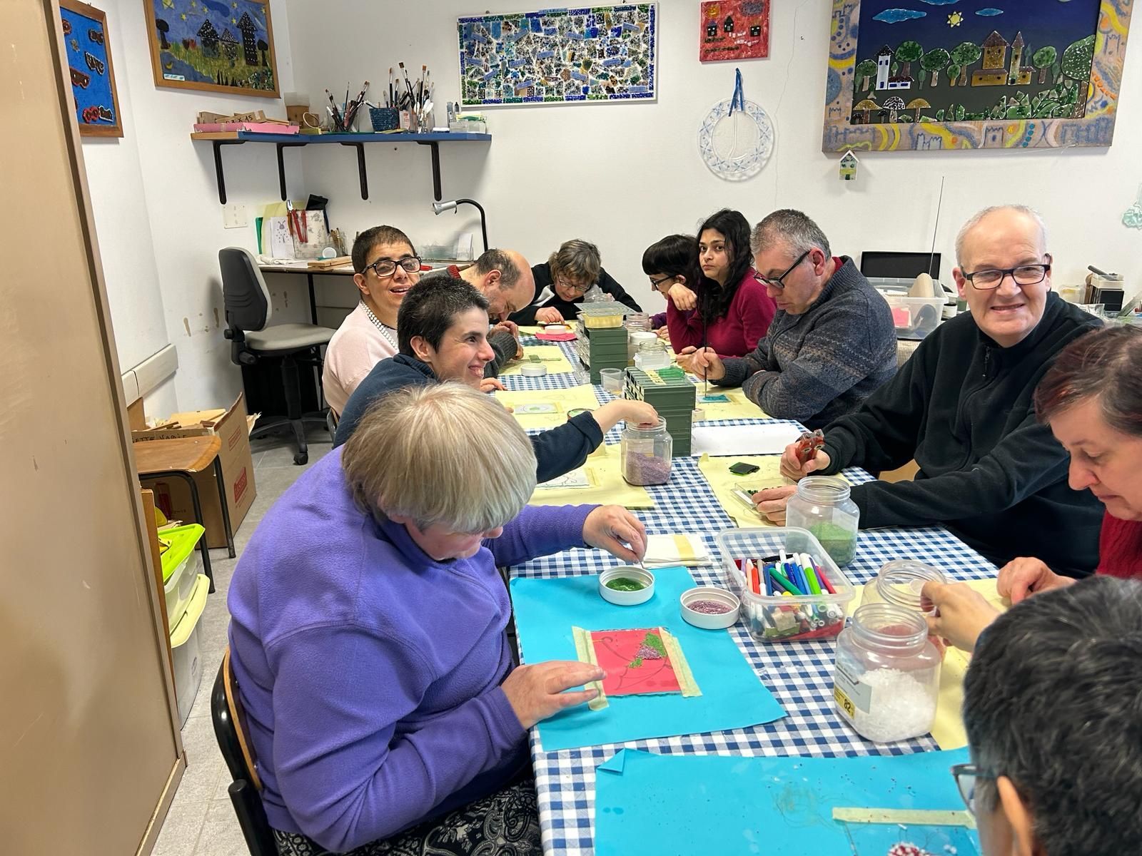 Un gruppo di persone è seduto attorno a un tavolo in una stanza.