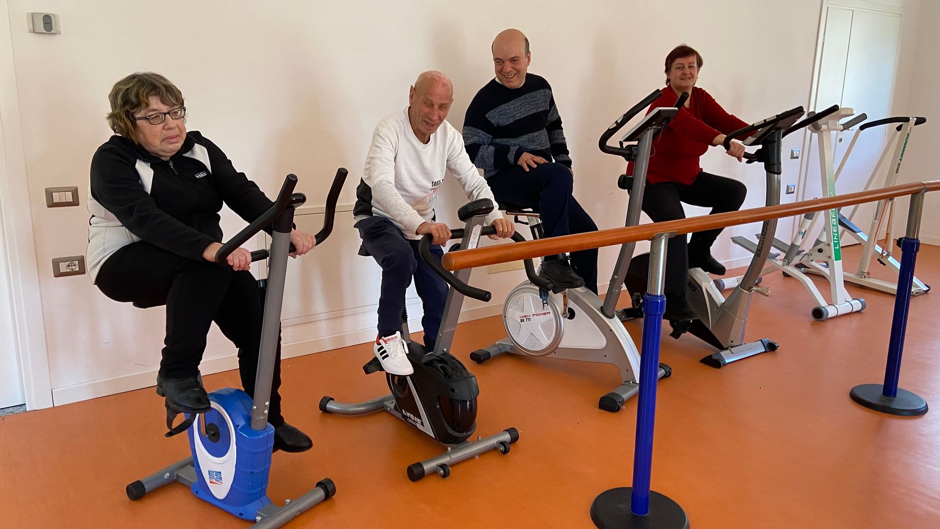 Un gruppo di persone sta pedalando su una cyclette in una palestra.