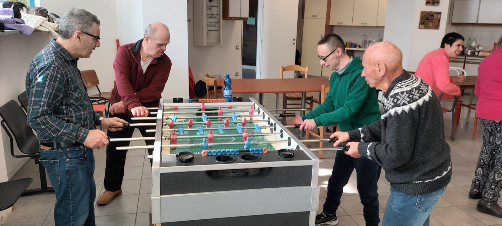 Un gruppo di uomini sta giocando a biliardino in una stanza.