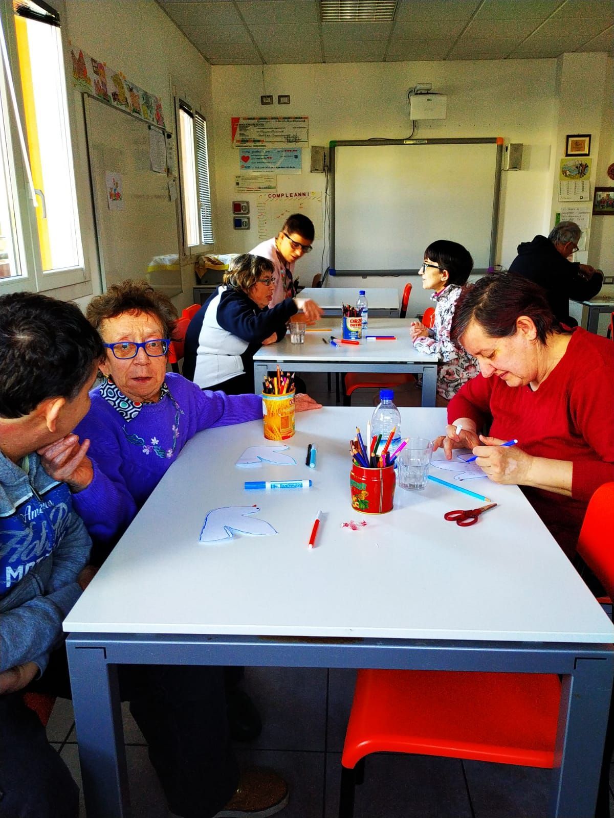 Un gruppo di persone è seduto ai tavoli di un’aula