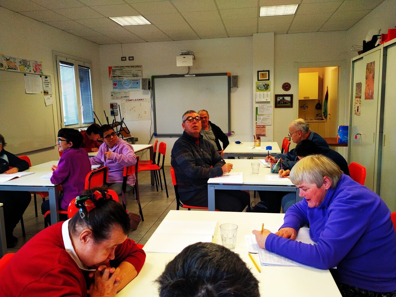 Un gruppo di persone è seduto ai tavoli di un’aula