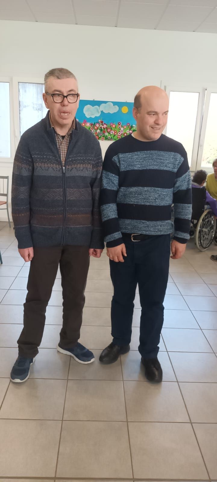 Due uomini sono in piedi uno accanto all'altro in una stanza.