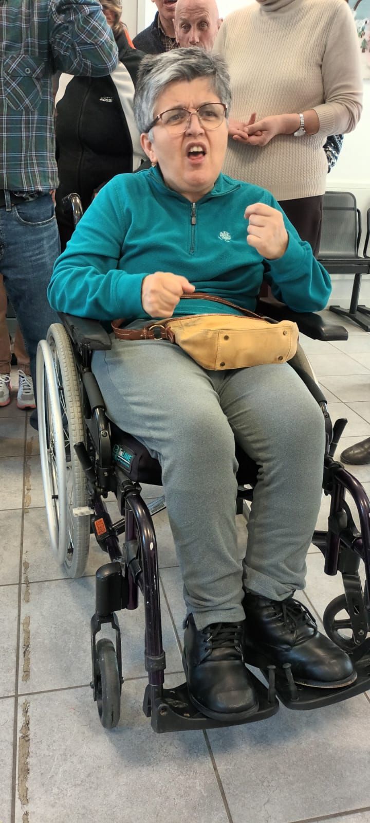 Una donna su una sedia a rotelle sta facendo una faccia buffa.