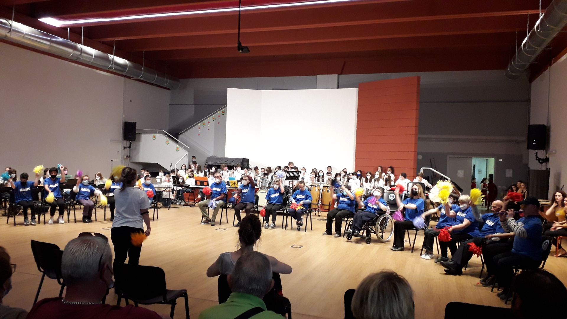 Un folto gruppo di persone è seduto sulle sedie in una grande stanza.