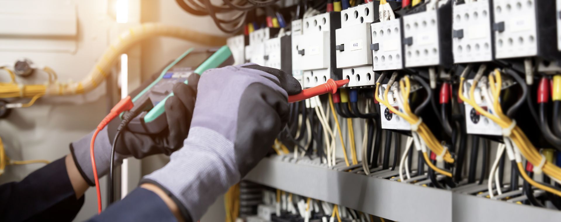 Electrician engineer tests electrical installations and wires on relay protection system. 