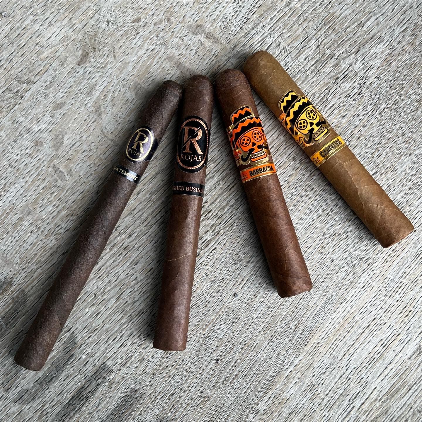 A group of cigars are lined up on a wooden table.