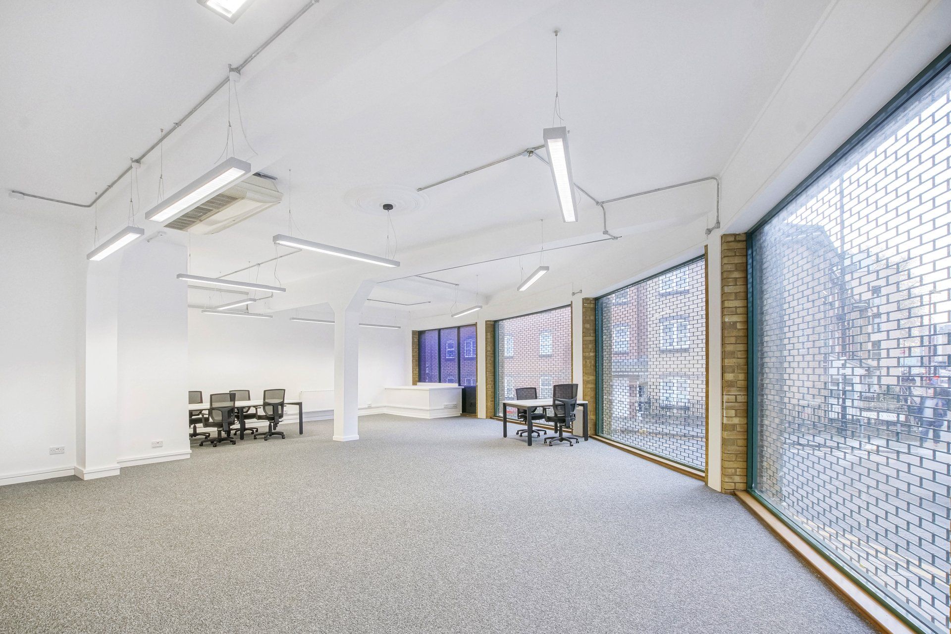 A large empty room with tables and chairs in it.