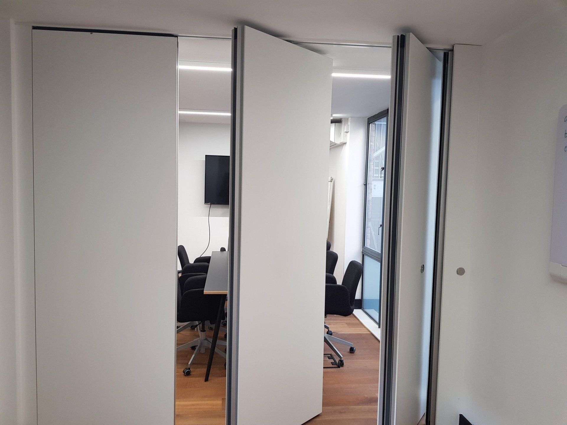 A room with a table and chairs behind a sliding door.