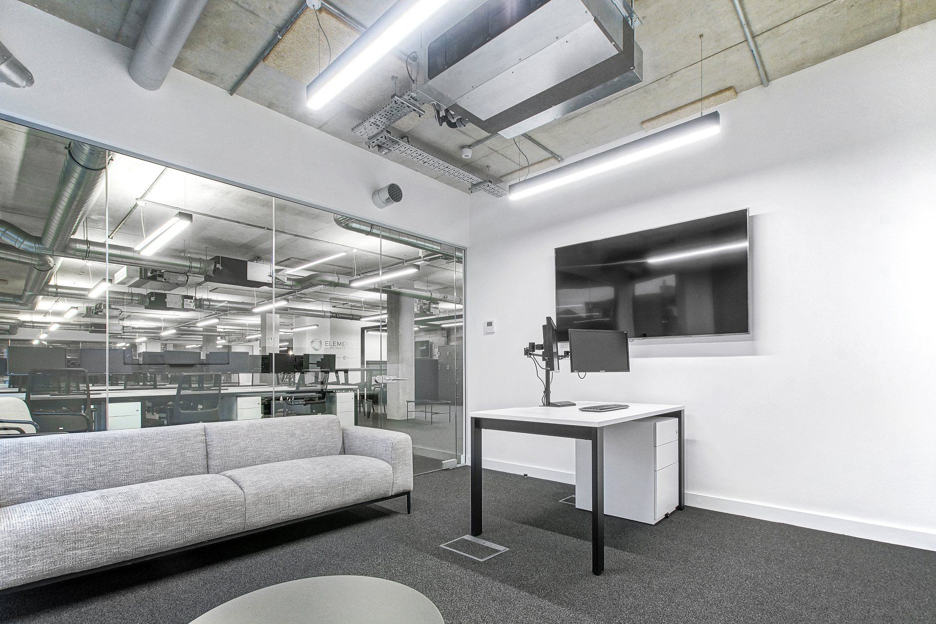 A living room with a couch , desk , and television.