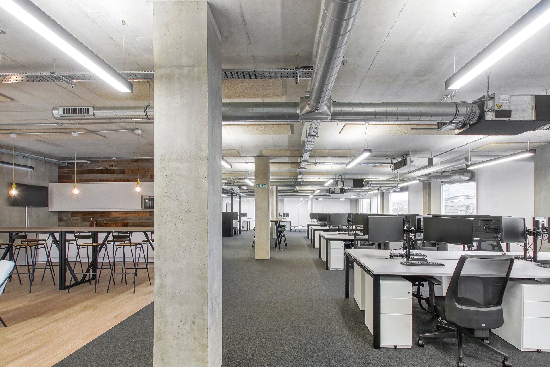 A large empty office with a lot of desks and chairs.