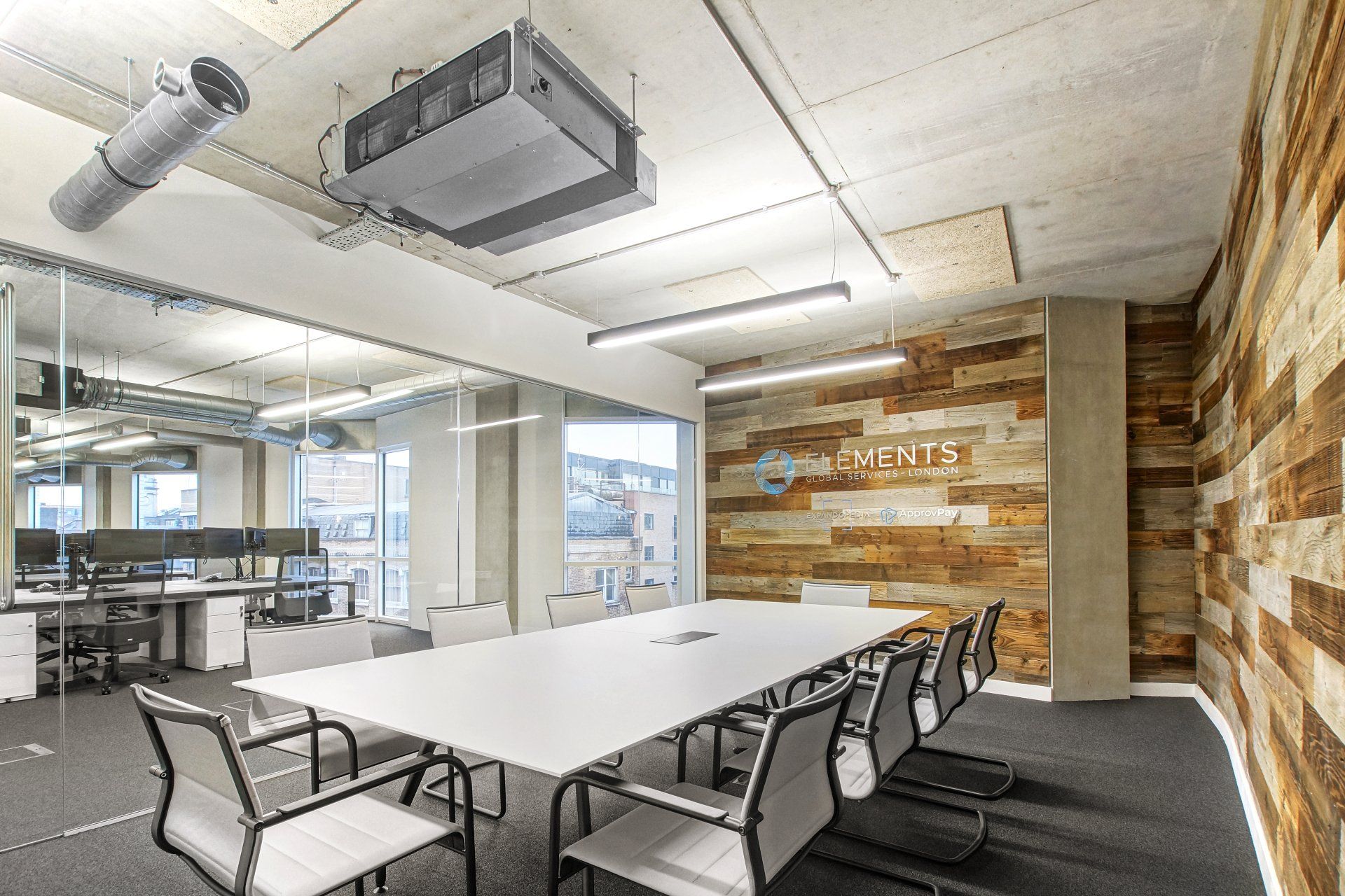 A conference room with a long table and chairs and a wooden wall.