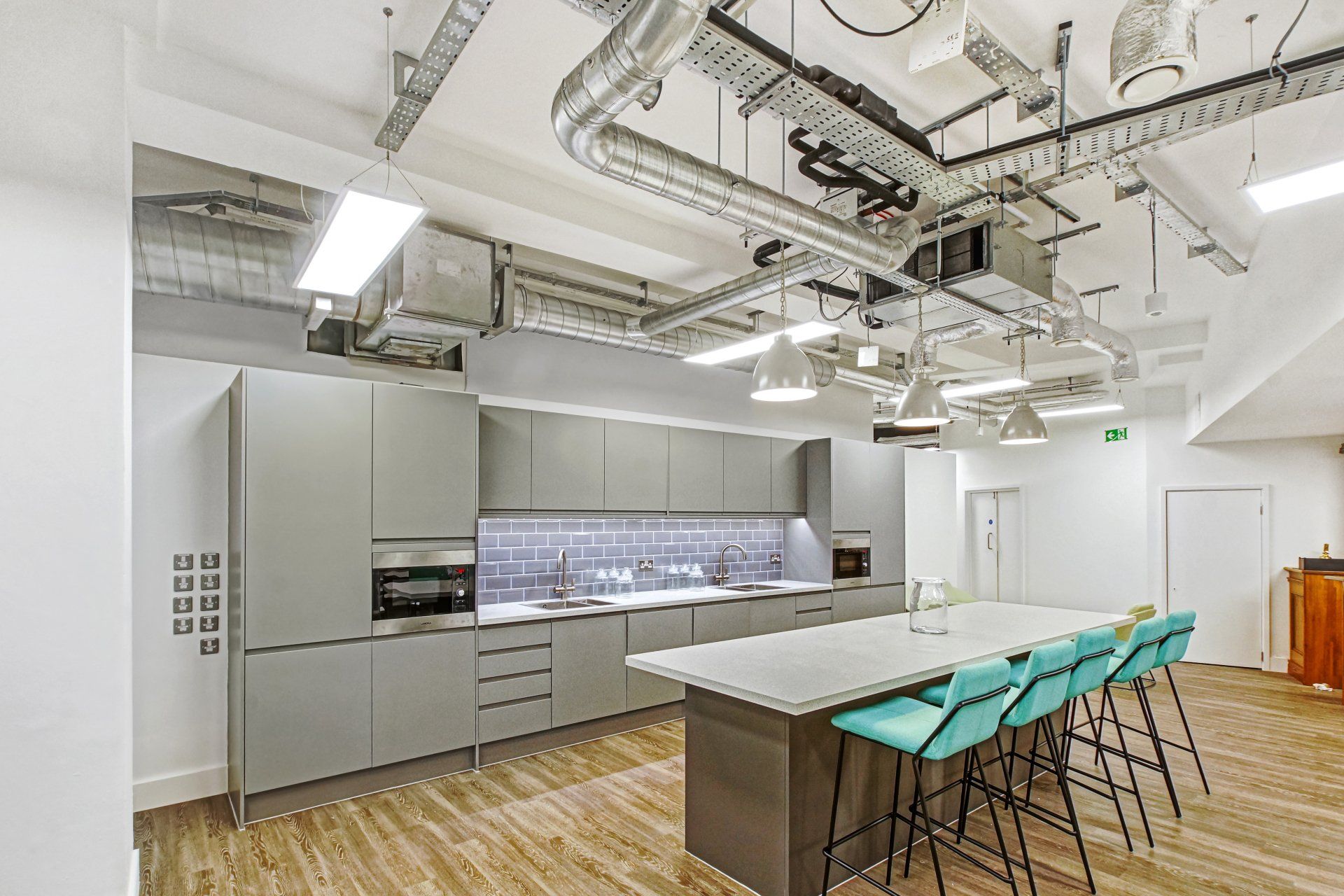 A large kitchen with a long table and stools.